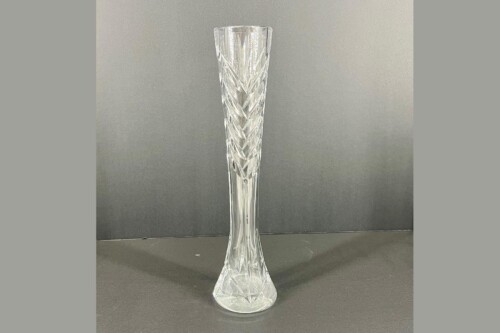 Crystal tall vase with intricate cut facets on a dark background.