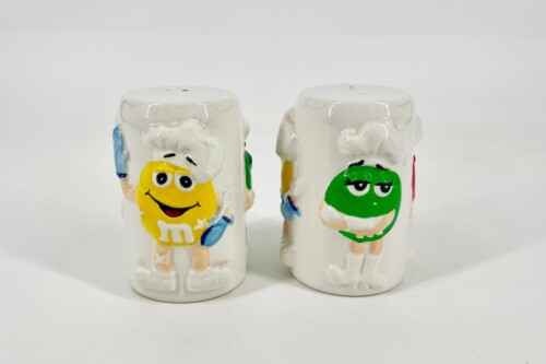 Two ceramic M&M-themed salt and pepper shakers with yellow and green cartoon faces.
