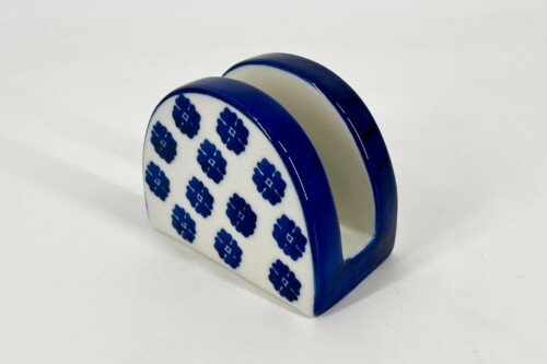 Ceramic napkin holder with a blue floral pattern on white, blue edge trim, viewed from an angle.