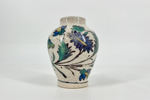 White ceramic vase with blue and green floral design and a crackled glaze, placed against a plain light background.