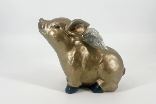 Gold-toned pig figurine with small silver wings, standing on dark feet against a plain white background.