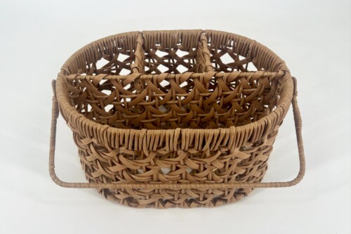 Close-up of a round, brown wicker basket with two handles.