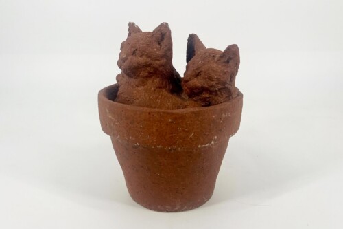 Terracotta pot holding three brown jagged rock-like clay sculptures.