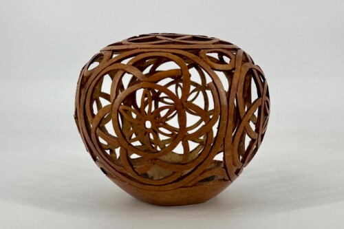 Intricate wooden sphere sculpture made from interlocking circular strips against a pale background, showcasing negative space patterns.] ,
