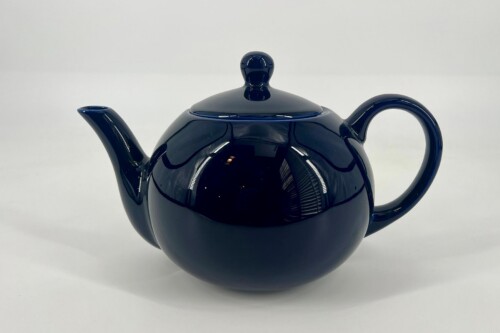 Glossy navy blue ceramic teapot with lid, spout to the left and a curved handle on a white background.