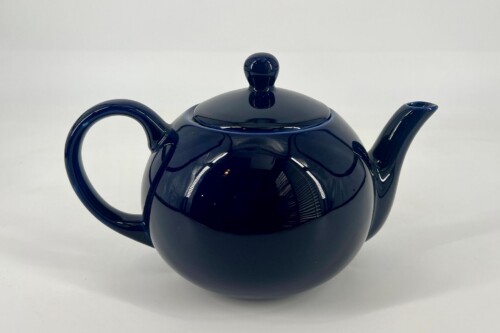 Dark blue ceramic teapot with a curved handle and rounded lid on a white background.