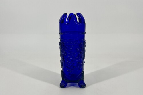 Blue glass sex toy standing upright on a light surface, featuring a ribbed shaft and a flared base.