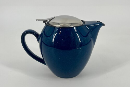 Blue ceramic teapot with a shiny metal lid, curved handle, and a protruding spout against a light background.