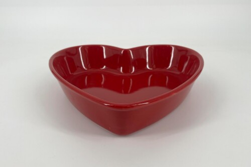 Red heart-shaped ceramic bowl with a glossy finish on a white background.
