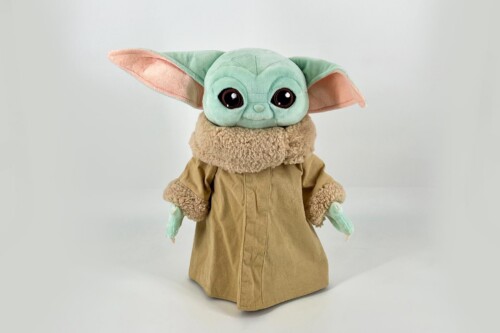 Mint-green Grogu plush toy with large dark eyes and oversized ears wearing a tan robe with fluffy collar and beige cuffs, facing forward.