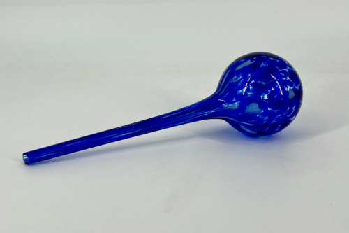 Blue glass dropper with a long slender stem and a bulb-shaped end resting on a white surface
