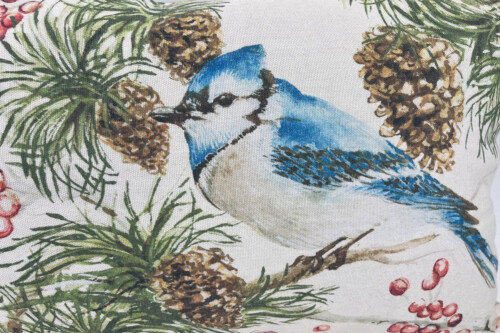 Decorative fabric pattern featuring a blue jay among pine cones and needles.