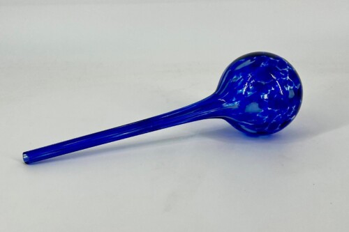 Blue glass dropper with a rounded bulb on the right, lying diagonally on a white surface.
