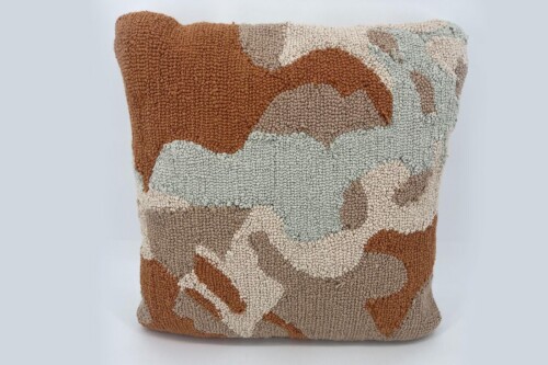 Plush textured throw pillow with an abstract camouflage pattern in brown, beige, and light blue tones.