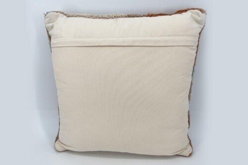 Cream-colored square throw pillow with brown crocheted edging against a light blue background.