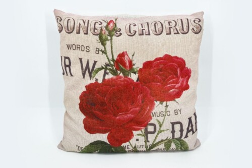 Beige decorative pillow with large red roses and vintage newspaper-style text in dark letters (song & chorus) across the front.