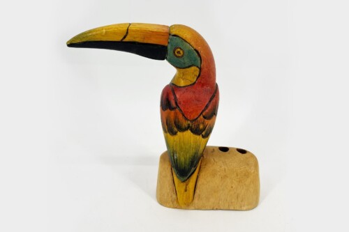 Colorful wooden parrot carving mounted on a wooden base.