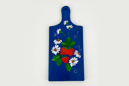 Blue wooden cutting board decorated with white daisies, red strawberries, and green leaves; a small hole at the top for hanging.