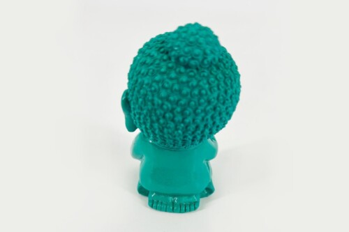 Back view of a teal plastic troll doll with bubble-textured hair and small feet against a light background.