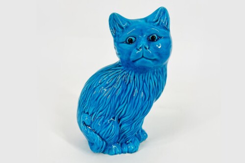 Blue glossy ceramic cat statue facing slightly to the right against a light background, decorative figurine.