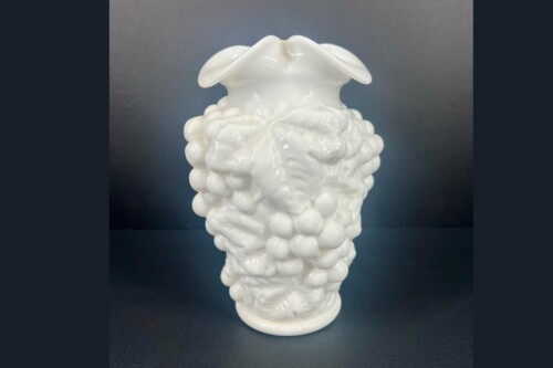White ceramic sculpture resembling a brain with bubble-like lobes and two wing-like top extensions against a dark background.