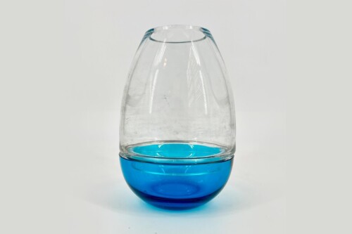 Stemless glass goblet with a vivid blue base and clear rounded bowl against a light background, studio shot.**