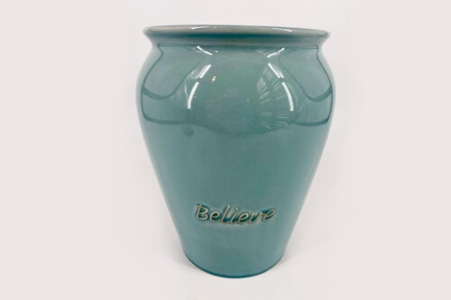 Teal ceramic vase with glossy glaze and the word 'Believe' in gold script along its front base area.