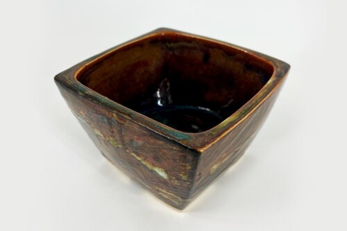 Square ceramic bowl with dark brown glaze and greenish rim, seen from above, empty interior