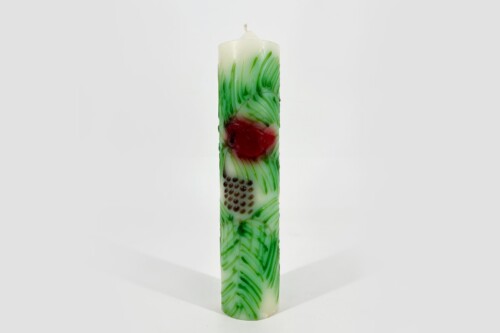 Tall white pillar candle with green marbling and a red central accent, set against a light background