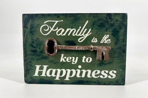 Green wooden sign with a rusted key and the phrase 'Family is the key to Happiness'.