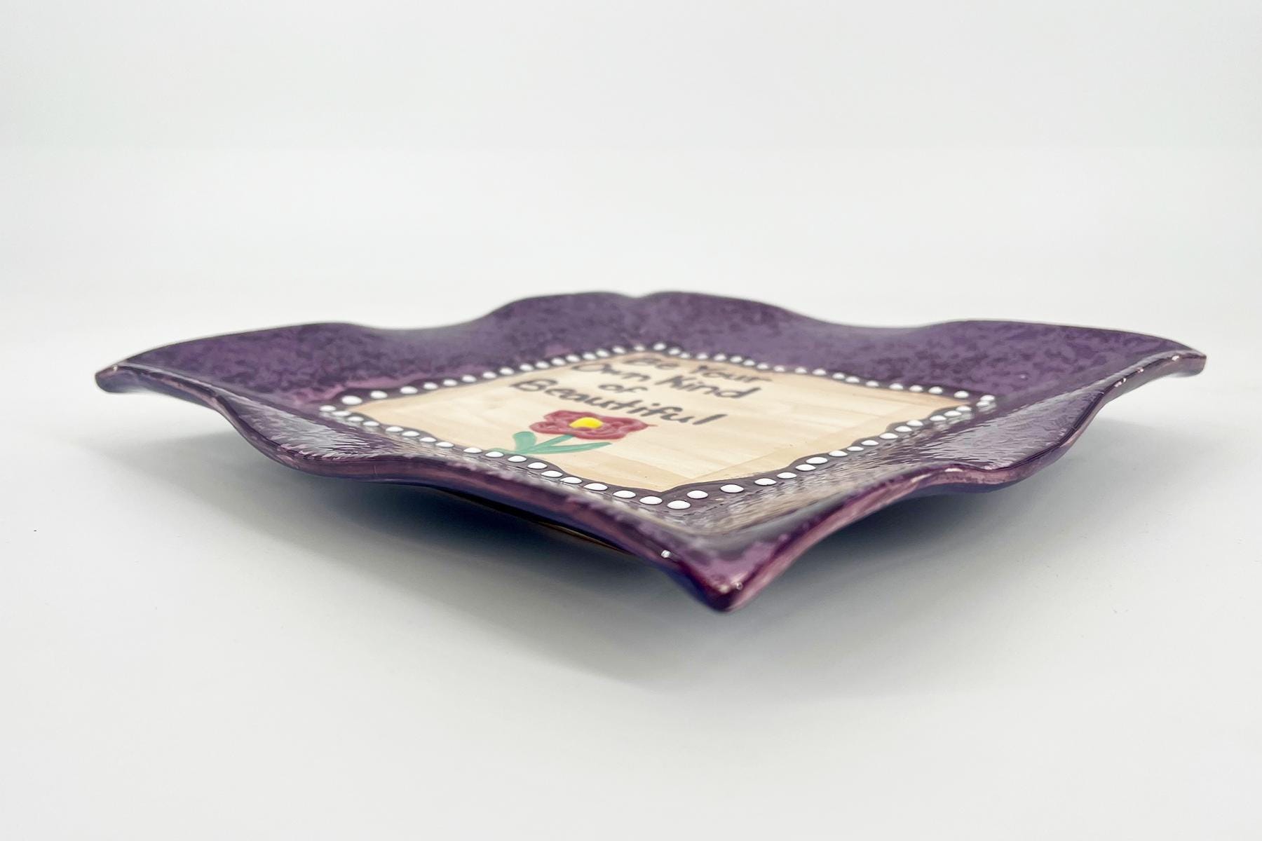 Purple decorative plate with scalloped edges, white bead border, and a beige center featuring a red rose and the words 'You are beautiful'.