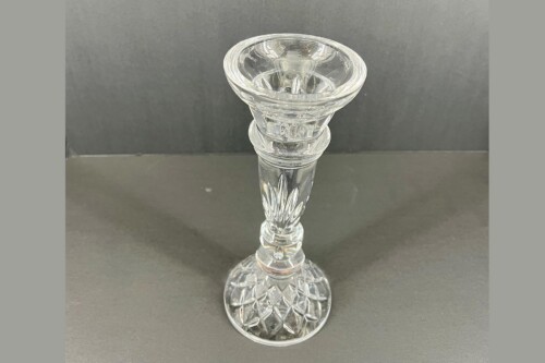 Crystal stemmed goblet with a wide, faceted bowl resting on a decorated stem and round base on a gray surface