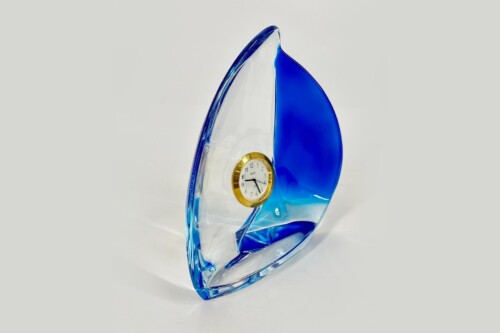 Blue and clear glass award in a curved sail shape with a small gold-rimmed clock embedded in the center