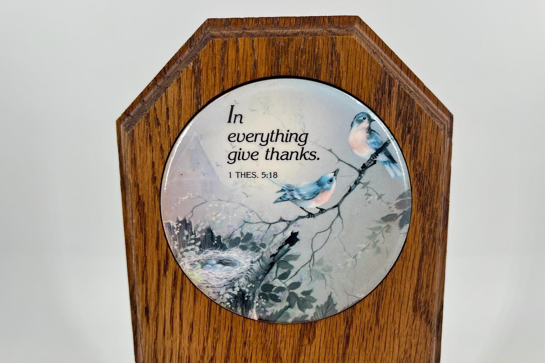 Wooden wall plaque with a circular ceramic insert showing two blue birds and the text 'In everything give thanks' (1 Thessalonians 5:18).