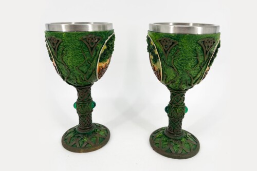 Pair of green decorative goblets with metal rims and vine-like reliefs on the cups and stems