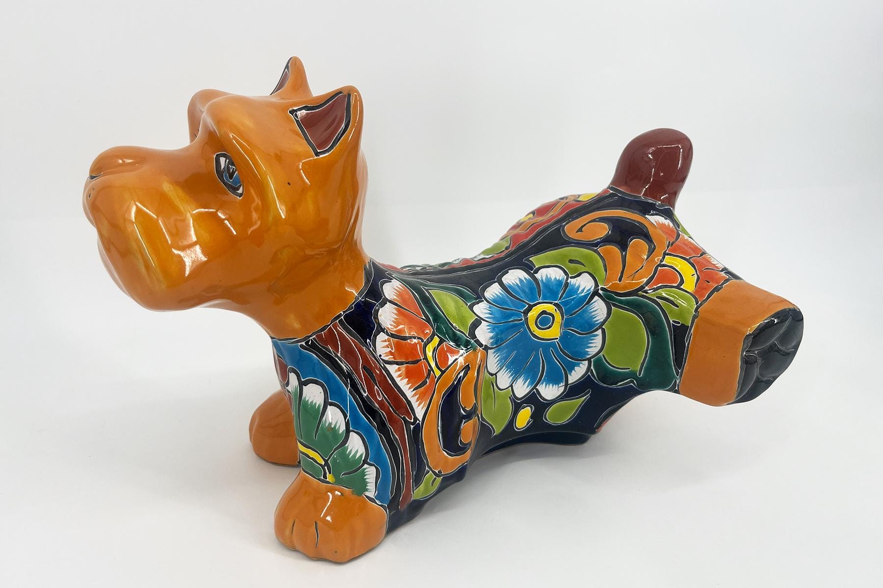 Colorful ceramic dachshund sculpture painted with blue, orange, and green floral patterns along its back.
