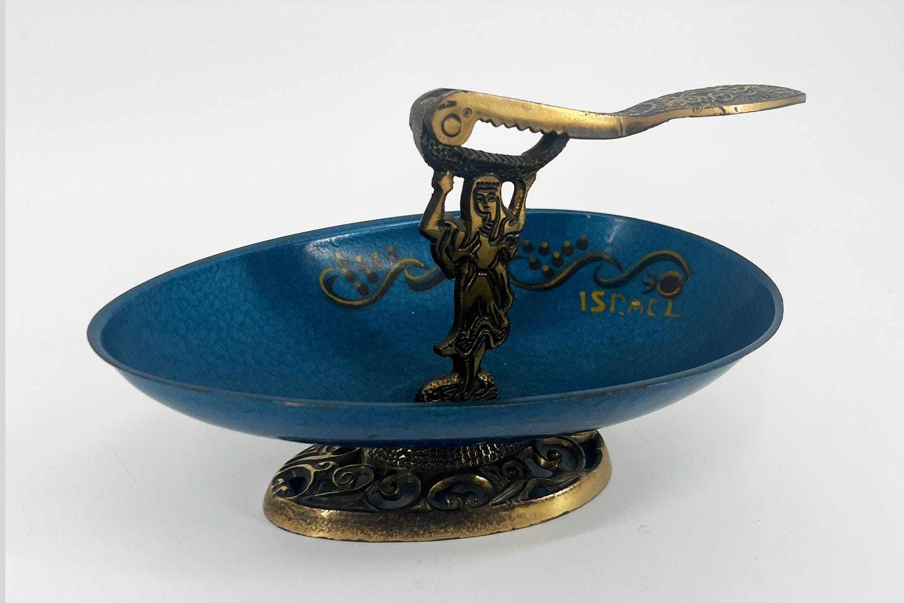 Bronze figurine of a woman holding a curved, serpent-like handle above a blue decorative bowl on a detailed pedestal base