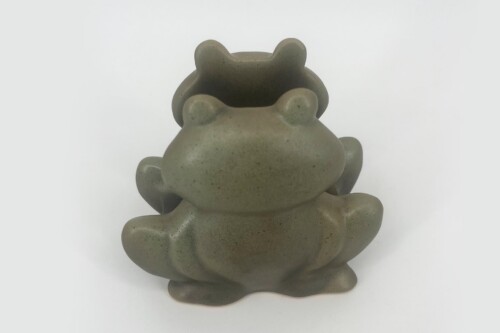 Two gray ceramic frog figurines stacked on top of each other, viewed from the back (decorative sculpture).