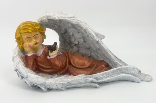 Angel figurine with yellow hair, eyes closed, resting on a cloud-like base while gently holding a small brown bird in its hand.