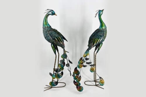 Pair of decorative metal peacock sculptures with teal-green patina facing each other on slender wire stands