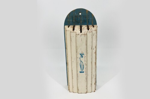 Vintage wooden sled with a blue curved head and chipped cream slats with a blue floral design.