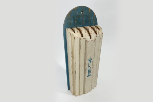 Tall weathered wooden sculpture with vertical slats, white distressed finish, blue curved top, and a subtle blue floral motif on the front surface.