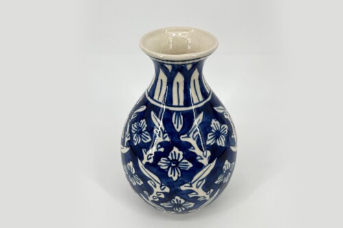 Blue and white ceramic vase with floral patterns, photographed against a light background.