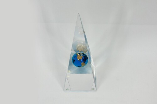 Clear acrylic triangular pyramid with two globes—white globe above blue globe—on a square base.