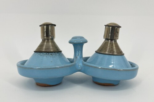 Blue ceramic double oil lamp base with two metal wick tubes and a central handle, set against a light background.