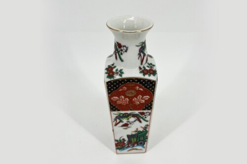 White porcelain vase with a gold rim and colorful floral and geometric patterns for display.