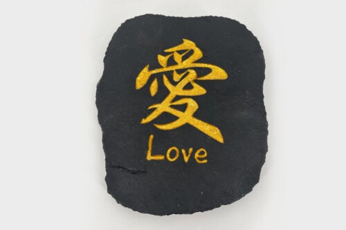 Black slate stone engraved with a gold Chinese character and the word 'Love' in gold lettering on its surface.