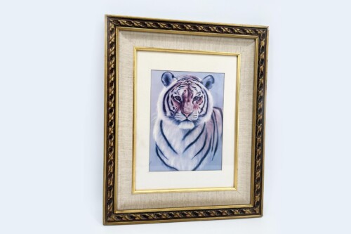Framed tiger portrait in a gold ornate frame hung on a pale blue wall