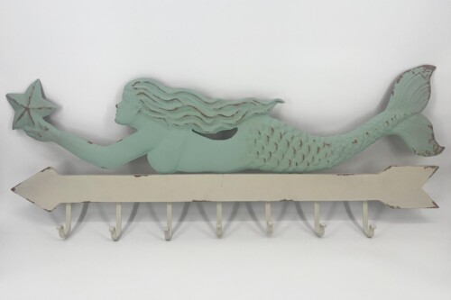 Mint-green mermaid sculpture with flowing hair, holding a starfish, mounted on a distressed white arrow plaque.