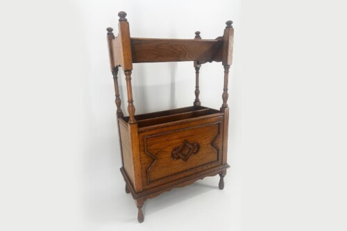 Antique wooden display stand with four turned posts and a lower storage box, featuring carved front panel.